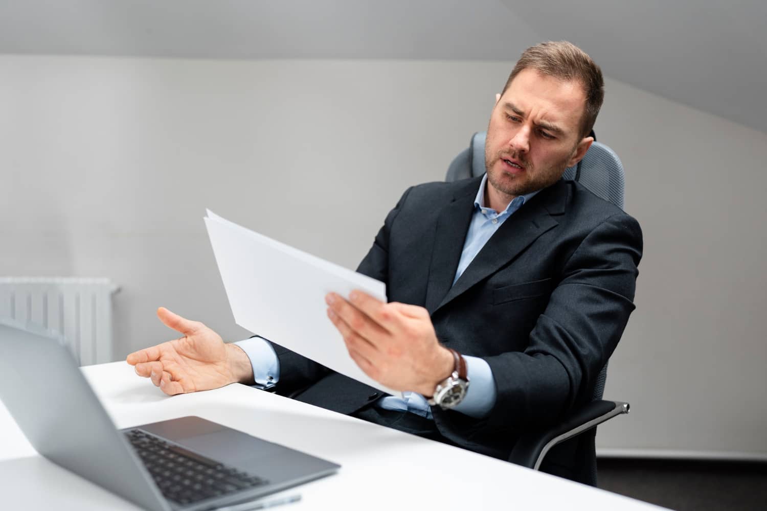 Un homme en costume tenant des documents, représentant la signature du reçu pour solde de tout compte.